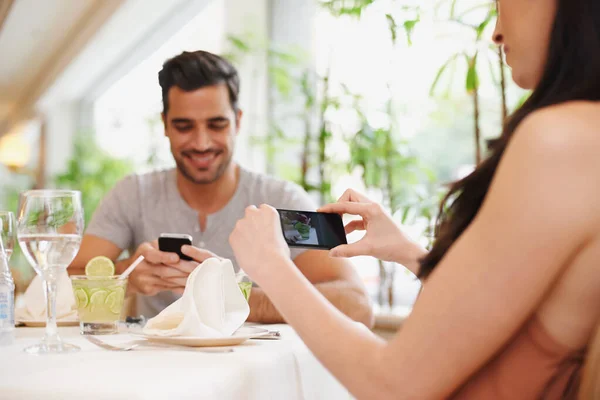 Memórias românticas. Uma mulher tirando uma foto enquanto janta fora com seu parceiro em um restaurante. — Fotografia de Stock