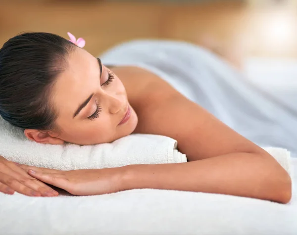 Die Erfahrung einer völlig heiteren Gemütsverfassung. Schnappschuss einer attraktiven jungen Frau, die sich in einem Wellnessbereich auf einem Massagetisch entspannt. — Stockfoto