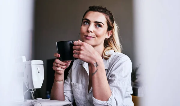 Il caffè è ciò che stimola il pensiero creativo. Foto ritagliata di una stilista che prende un caffè alla scrivania. — Foto Stock