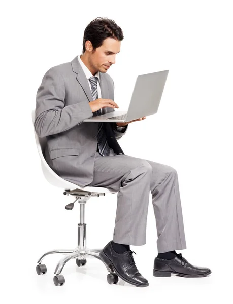 Ansluten. En fokuserad ung chef arbetar på sin bärbara dator medan isolerad på vit. — Stockfoto
