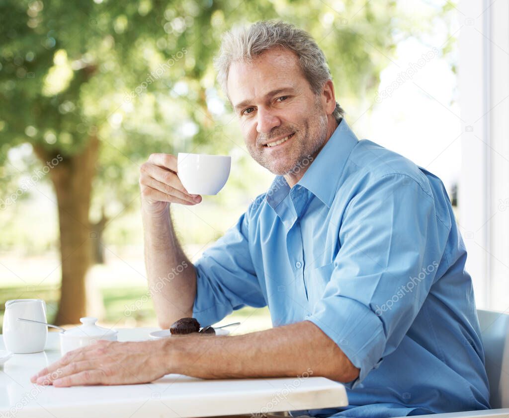Relaxing with his daily coffee. Happy mature man enjoying a cup of coffee outdoors.