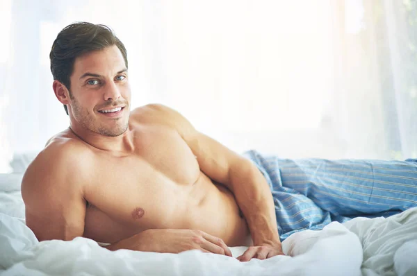 Este é o meu look de fim de semana. Retrato de um homem bonito relaxando na cama pela manhã. — Fotografia de Stock