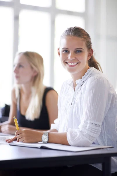 J'adore la biologie. Une adolescente souriante assise dans une salle de classe. — Photo