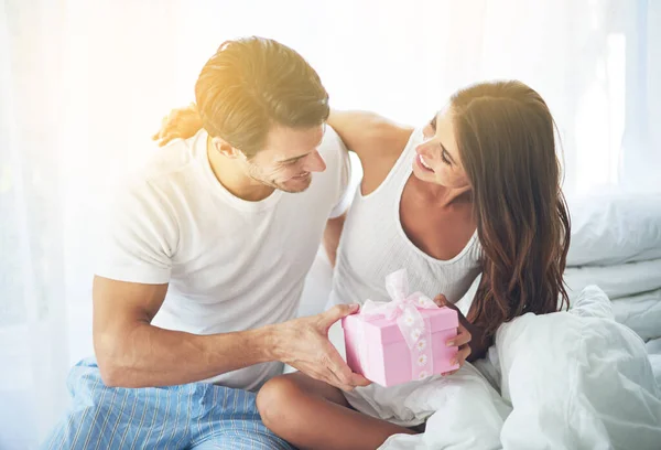 Tengo una pequeña sorpresa para ti. Shot de un marido cariñoso dando a su esposa un regalo. —  Fotos de Stock