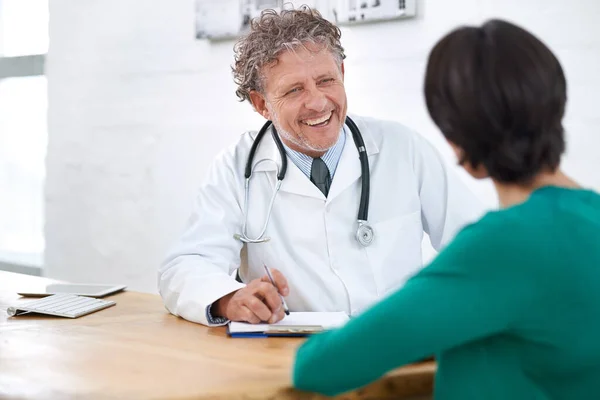 Tiene un trato maravilloso con la cabecera. Inyección de un médico maduro sonriente teniendo una consulta con un paciente. — Foto de Stock