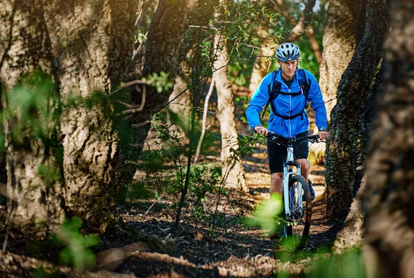 Forest fitness fanatic. Shot of a male cyclist riding along a mountain bike trail. — Stock Photo, Image