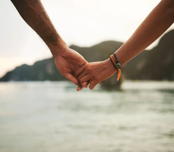 Εξερευνήστε τον κόσμο με αυτόν που αγαπάτε. Κοντινό πλάνο ενός νεαρού ζευγαριού να κρατιέται χέρι-χέρι στην παραλία.. — Φωτογραφία Αρχείου