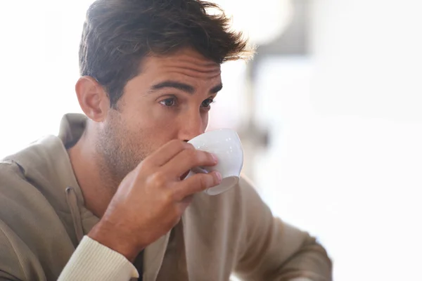 Jag får min dagliga dos kaffe. Skjuten av en stilig ung man som dricker kaffe på ett kafé. — Stockfoto