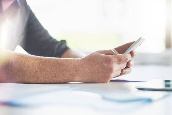 Digitalizar la jornada laboral. Primer plano de un hombre de negocios irreconocible enviando mensajes de texto en un teléfono celular en una oficina. — Foto de Stock