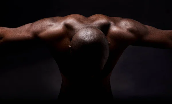Muscoli puri e mascolinità. Studio shot di un uomo muscoloso afroamericano appoggiato in avanti. — Foto Stock