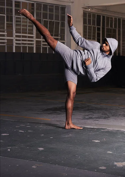 En iyi olmak için eğitim. Bir otoparkta dövüş sanatları yapan çıplak ayaklı genç bir adamın fotoğrafı.. — Stok fotoğraf
