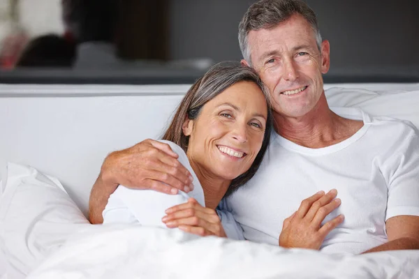 Zeit zum Kuscheln. Porträt eines liebevollen reifen Paares beim Kuscheln im Bett. — Stockfoto