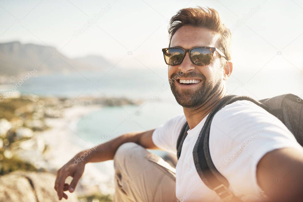 Selfies with a view. Cropped portrait of a handsome young man taking selfies while hiking in the mountains.