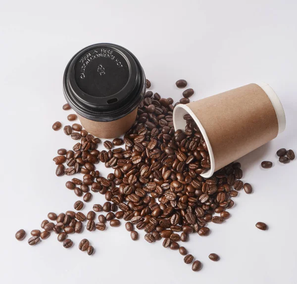 コーヒーから始めなさい。グレーの背景にコーヒー豆で満たされた紙コップの先端のスタジオショット. — ストック写真