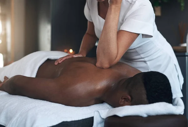 Om de spanning op te lossen. Shot van een jonge man het krijgen van een rug massage in een spa. — Stockfoto