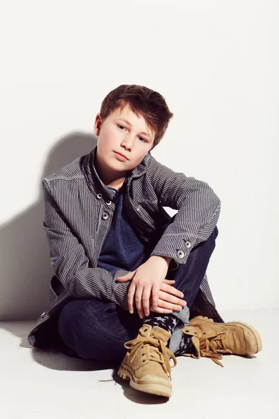 Relaxed and easy style. Young adolescent boy sitting against a white background. — Stock Photo, Image