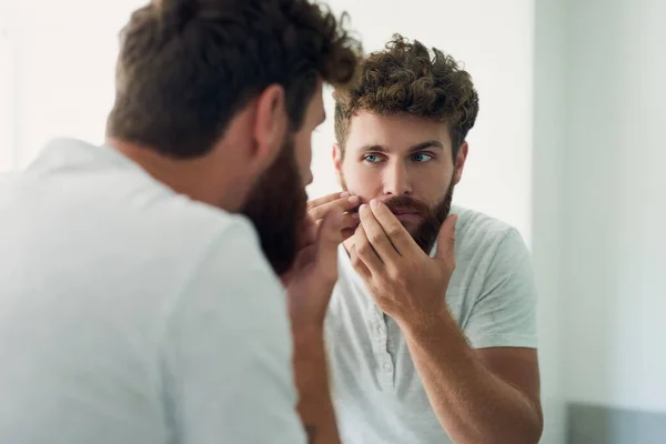 Dělám ranní prohlídku. Vystřižený záběr pohledného mladého muže, jak si prohlíží kůži v zrcadle v koupelně. — Stock fotografie