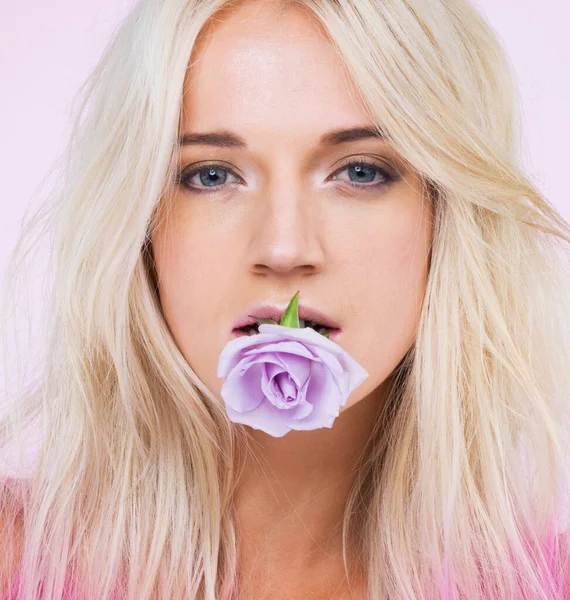 Frais comme une fleur. Un portrait studio d'une belle jeune femme avec une rose violette dans la bouche. — Photo