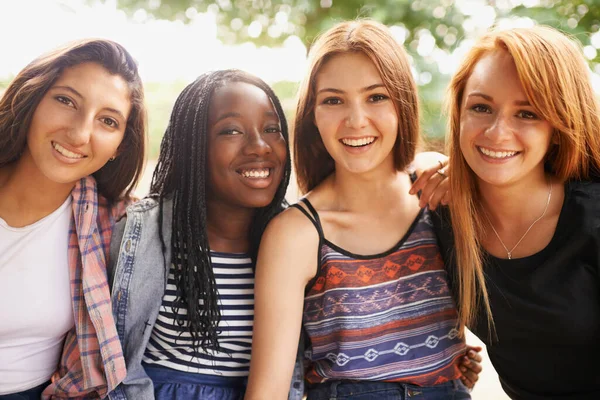Sono l'arcobaleno di questa nazione. Quattro belle ragazze sorridenti felicemente mentre si siedono fuori. — Foto Stock