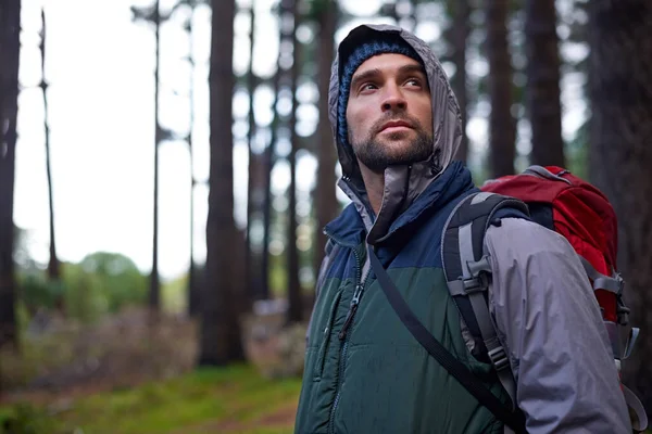 Vandring i det vilda. Porträtt av en ung man i ryggsäck när han vandrar i skogen. — Stockfoto