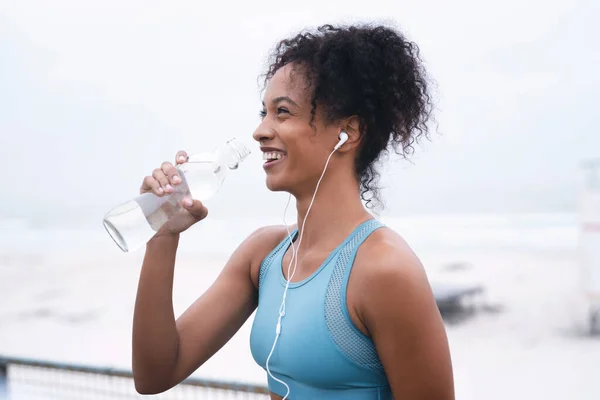 물은 체온 을조 절하고 관절의 윤활유 역할을 한다. 실외에서 운동을 하고 있는 한 젊은 여성 이술을 마시고 있는 장면. — 스톡 사진