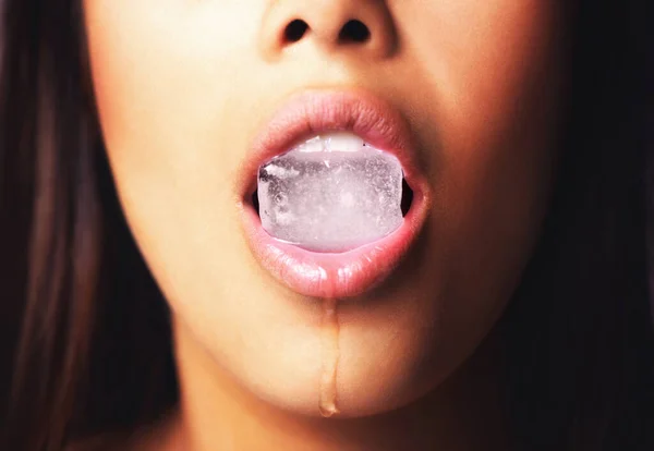 Su belleza te derretirá. Un disparo de una mujer sosteniendo un bloque de hielo en su boca. — Foto de Stock