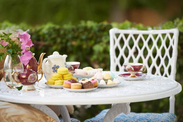 Vysoký čaj. Stůl vyzdobený chutnými pamlsky a čajem. — Stock fotografie