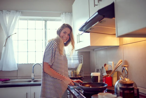 Готовлю одно из ее классических блюд. Портрет привлекательной молодой женщины, готовящей на кухне. — стоковое фото