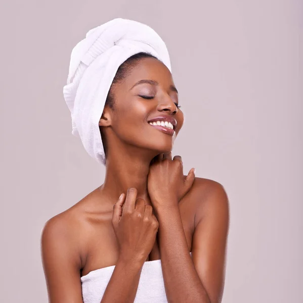 Skin that begs to be touched. An isolated studio shot of a beautiful young woman wearing a towel on her head. — Stock Photo, Image