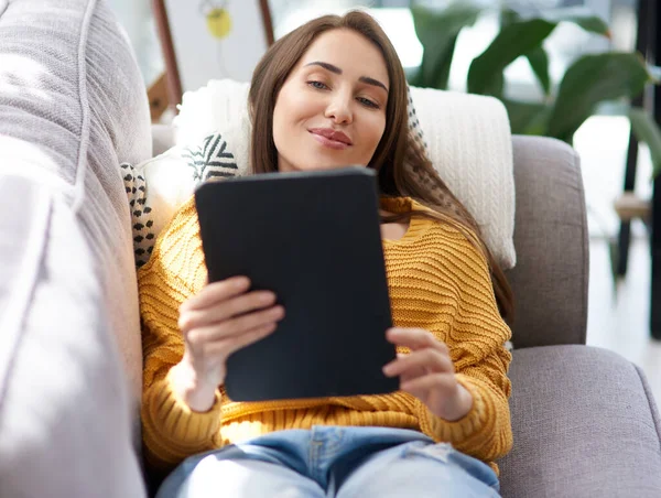 Rimanendo per il fine settimana più rilassante. Girato di una giovane donna che usa un tablet digitale mentre si rilassa su un divano a casa. — Foto Stock
