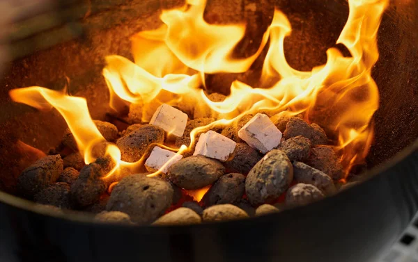 Diversão à lareira. Fechar de um fogo quente que queima em um churrasco. — Fotografia de Stock
