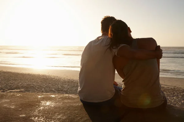 Livet er perfekt med deg ved min side. Silhouette av et par som sitter ved siden av hverandre på stranden.. – stockfoto