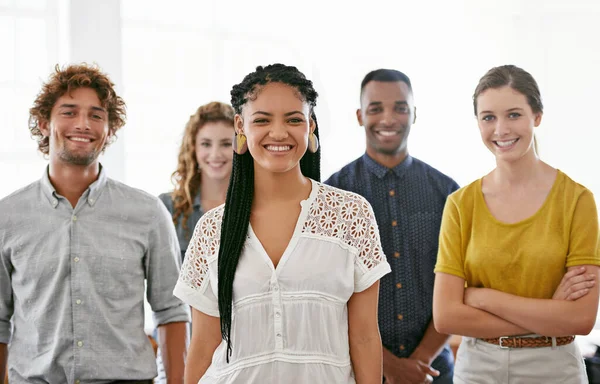 Είναι αφοσιωμένη ομάδα. Καλλιεργημένη προσωπογραφία μιας ποικιλόμορφης ομάδας νέων συναδέλφων που στέκονται σε ένα φωτεινό γραφείο. — Φωτογραφία Αρχείου