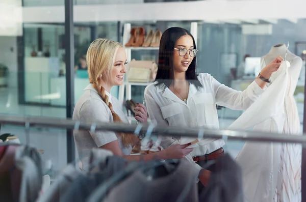 Můžu si to nechat udělat ve tvé velikosti. Shot of a sales assistant helping a young woman in a clothes boutique. — Stock fotografie