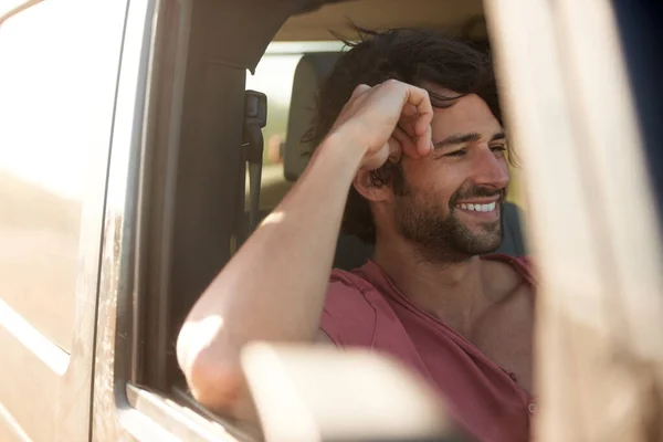 Despreocupado na estrada. Um jovem sorrindo e rindo em uma viagem de carro. — Fotografia de Stock
