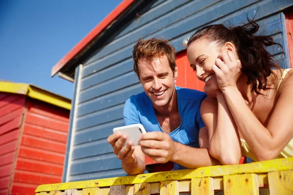 Take a look at this pic. Cropped shot of a couple looking at photos while on holiday. — Stock Photo, Image