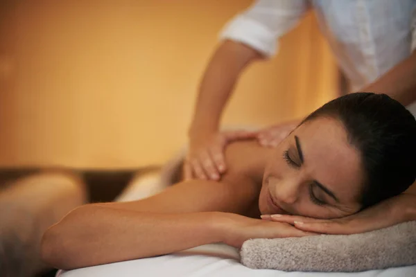 Göra sig av med de där knutarna. Skott av en attraktiv kvinna njuter av en avkopplande massage. — Stockfoto