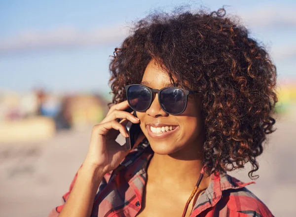 Io sono qui... voglio vedermi. Una giovane donna afroamericana alla moda sorridente mentre usa il suo cellulare. — Foto Stock