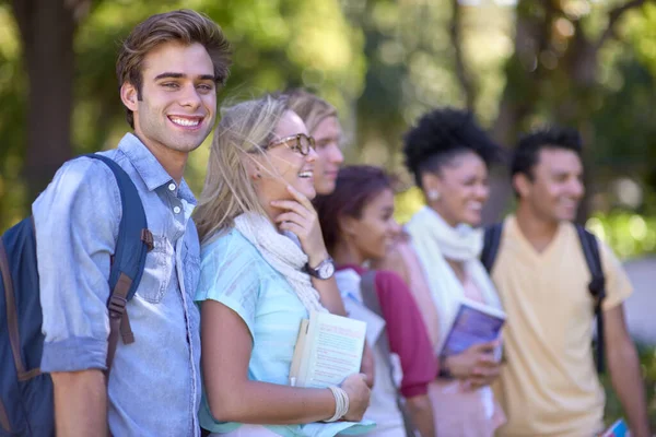 Entusiasmado com a faculdade. Um grupo de estudantes de pé em uma fila no campus. — Fotografia de Stock