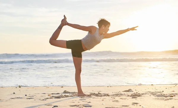 Je kunt niet fout gaan met yoga. Foto van een jonge vrouw die yoga beoefent op het strand. — Stockfoto