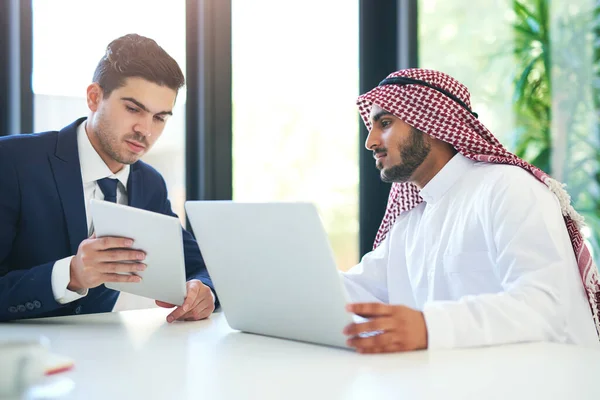Bezpłatne zestawy umiejętności dla udanej współpracy. Strzał młodego muzułmańskiego biznesmena przy użyciu laptopa i tabletu cyfrowego z kolegą w pracy. — Zdjęcie stockowe