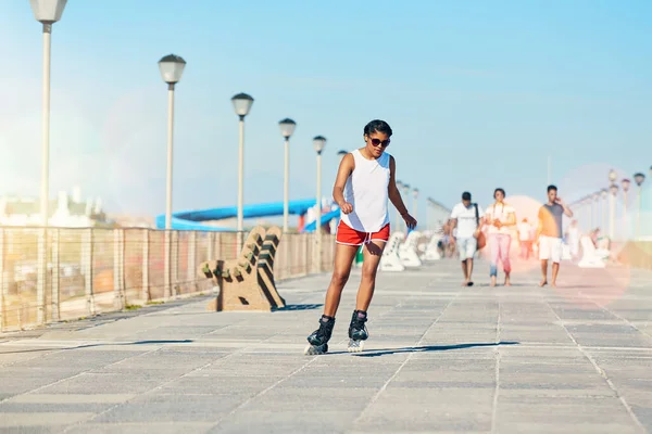 Fit bleiben und Spaß haben. Aufnahme einer attraktiven jungen Frau beim Inlineskaten auf einer Promenade. — Stockfoto