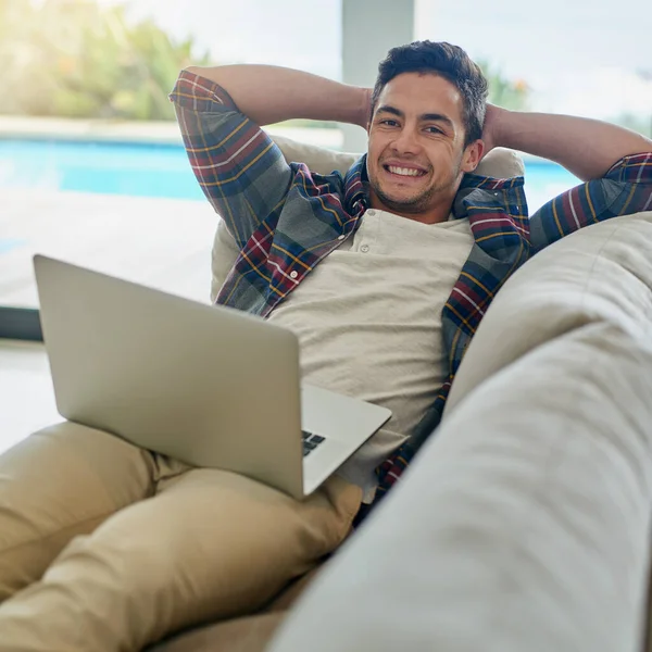 Dit noem ik nou ontspannen leven. Portret van een ontspannen jongeman met een laptop op de bank thuis. — Stockfoto