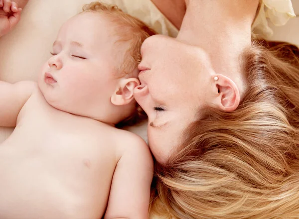 No closer bond than a mother and her child. Tiny baby boy lying fast asleep alongside his mother. Royalty Free Stock Images