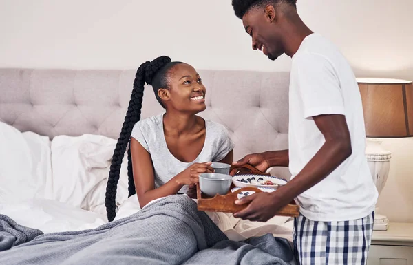 You werent feeling well so i made breakfast. Shot of a young man bringing his girlfriend breakfast in bed. — Stock Photo, Image