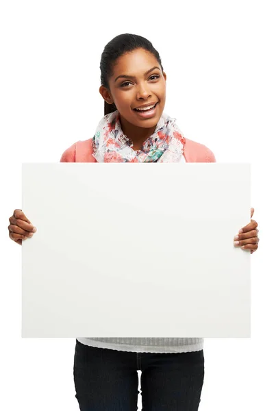 A segurar a tua mensagem com um sorriso. Jovem mulher Casual segurando espaço em branco contra um fundo branco. — Fotografia de Stock