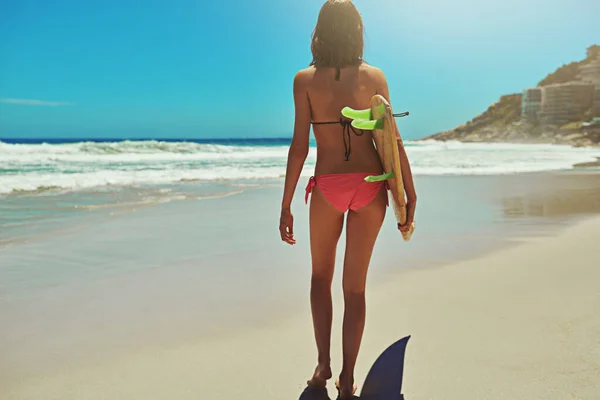 Nie może trzymać się z dala od wody. Zdjęcie z tyłu młodej i seksownej surferki na plaży. — Zdjęcie stockowe