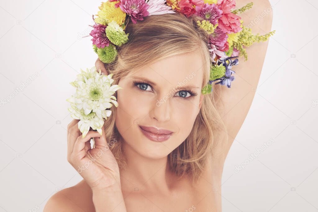 Feeling like a spring goddess. A young woman with a flower arrangement in her hair smiling at the camera.