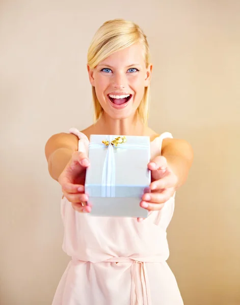 Surprise - c'est pour vous. Portrait d'une jeune femme tenant un coffret cadeau et souriant. — Photo