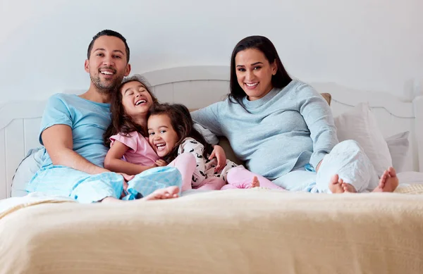 Αυτό που κάνει ένα σπίτι σπίτι είναι η οικογένεια που ζει σε αυτό. Ένα ζευγάρι ξαπλωμένο στο κρεβάτι με τις δύο κόρες τους.. — Φωτογραφία Αρχείου